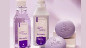 Linha de produtos “Meu Bem Estar” da Água de Cheiro, com fragrância de lavanda, composta por sabonetes redondos, um frasco de sabonete líquido roxo translúcido e um frasco de loção corporal lilás. Todos os itens têm embalagens em tons de lavanda com design clean e elegante.